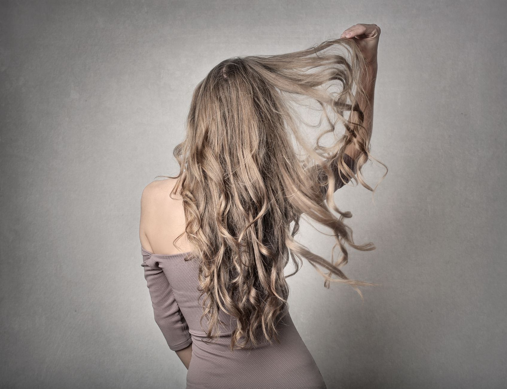 Long wavy hair swept back mid-movement